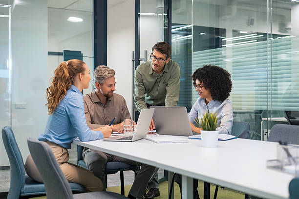 istock Group of young modern people in formalwear using modern technologies while working in the creative office 2215725078