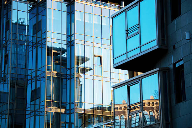 istock Contemporary Urban Architecture featuring Glass building Facades with reflections surrounding structures. Juxtaposition sleek modern design classic elements, cityscape elegance and structural details 2215725113