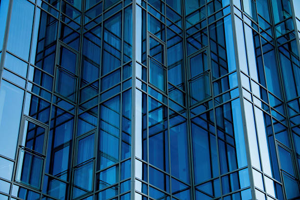 istock Modern Architecture Office Building Facade featuring Bluetinted Glass Panels and complex Geometric Pattern. Reflective surfaces and Sleek lines accentuate contemporary urban development 2215725170