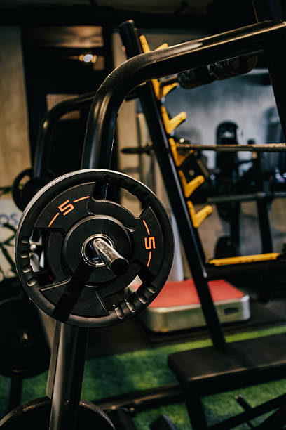 istock Wights and barbells arranged on racks in the gym. Exercise equipment ready for training. 2215725405