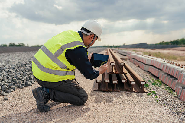 istock Engineer capturing data of stacked steel rails using tablet at railway construction site. 2215732842