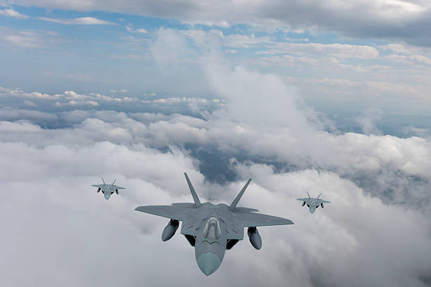 istock F-22 jet aircrafts flying over clouds. 2215733515