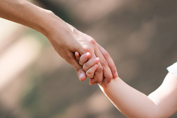 istock Little child holds his mother's hand 2215735246