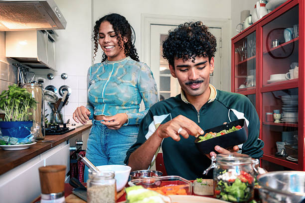 istock young woman and smiling man preparing lunch boxes in kitchen for take away 2215736415