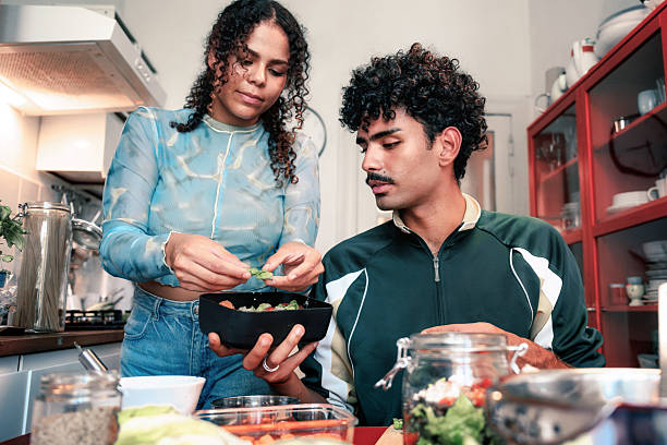 istock young woman and smiling man preparing lunch boxes in kitchen for take away 2215736421