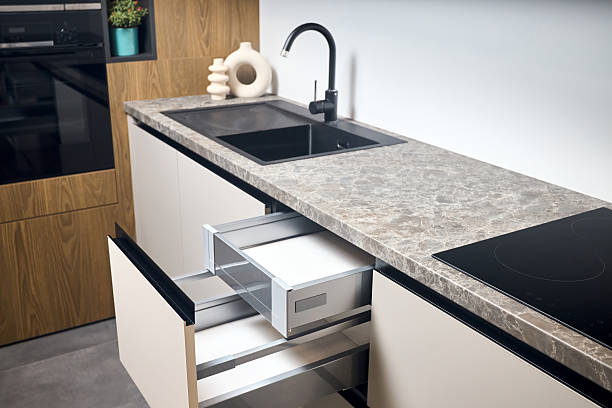 istock Horizontal sliding pull out drawer cabinet shelves storage in kitchen cupboard with beige panels under stoneware countertop toptable black sink basin and facet. 2215736451