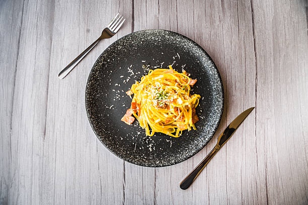 istock Carbonara with ham cream and cheese served on a black plate 2215757275