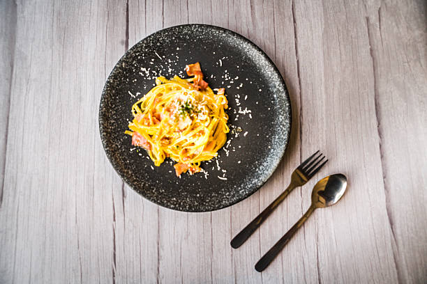 istock Carbonara with ham cream and cheese served on a black plate 2215757293
