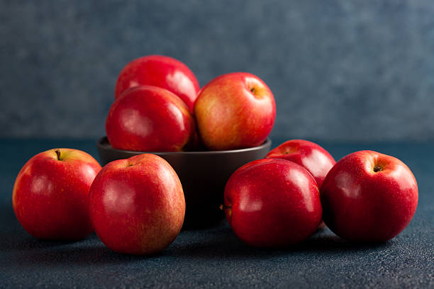 istock Bowl of Red Apples on Blue Background 2215757319