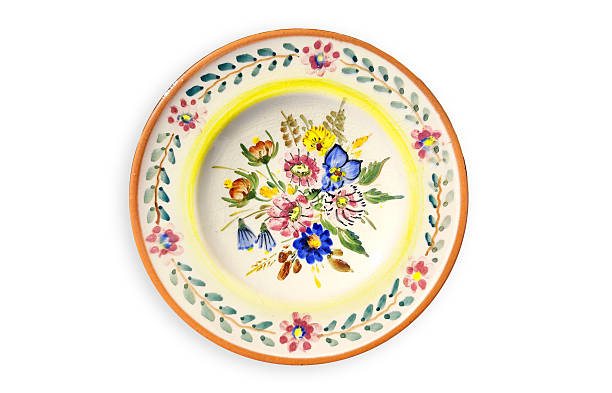 istock Close-up of a decorated ceramic plate, antique earthenware plate with ornament with a pattern of flowers in isolation on a white background. 2215757519
