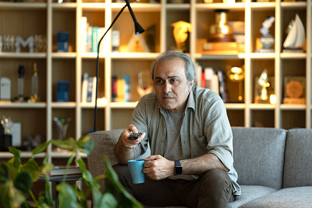 istock Senior man enjoys watching tv at home 2215761832