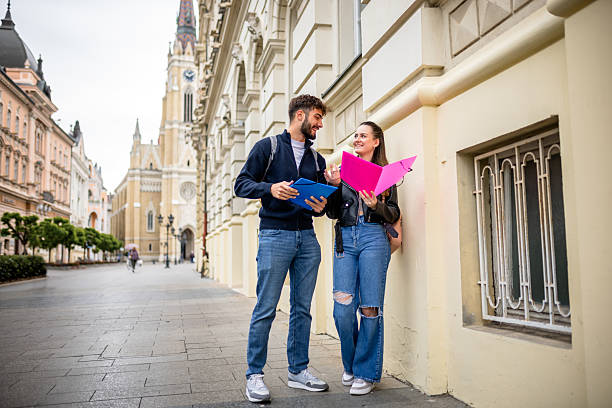 istock Two Students Walking and Studying Literature Together Outdoors 2215764308