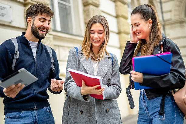 istock Three students discuss lectures and literature while they are outside. 2215764725