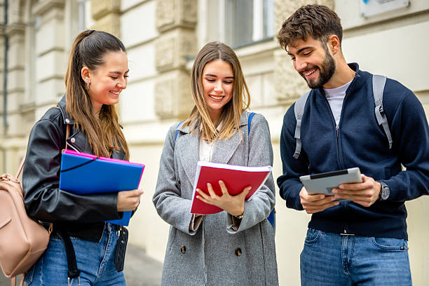 istock Three students discuss lectures and literature while they are outside. 2215764727