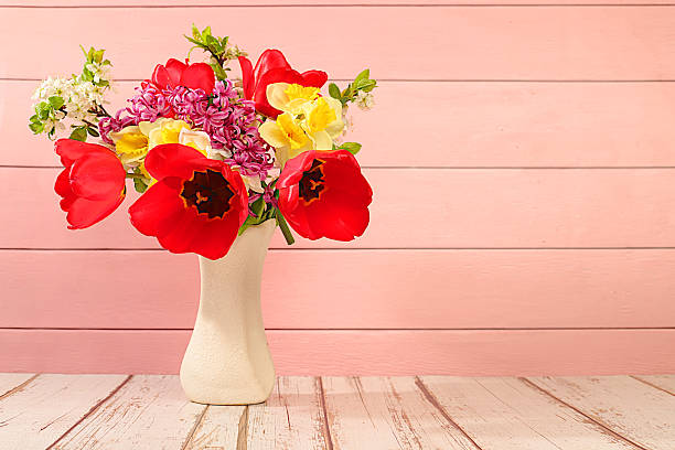 istock Beautiful spring blooming tulips, daffodils, hyacinths and cherry branches in vase on elegant background. Abstract floral arrangement and banner for screen, Still life, Floral holiday card with summer greeting concept. 2215773786