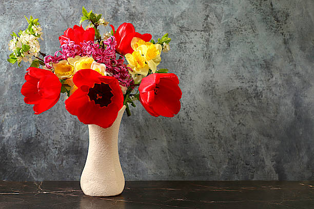 istock Beautiful spring blooming tulips, daffodils, hyacinths and cherry branches in vase on elegant background. Abstract floral arrangement and banner for screen, Still life, Floral holiday card with summer greeting concept. 2215773787