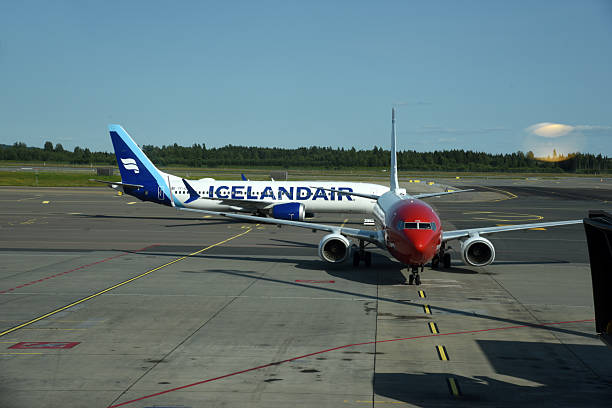 Oslo Airport Gardermoen is an international airport serving Oslo, the capital and most populous city of Norway. The image shows two aircrafts on the airfield, captured during summer season.