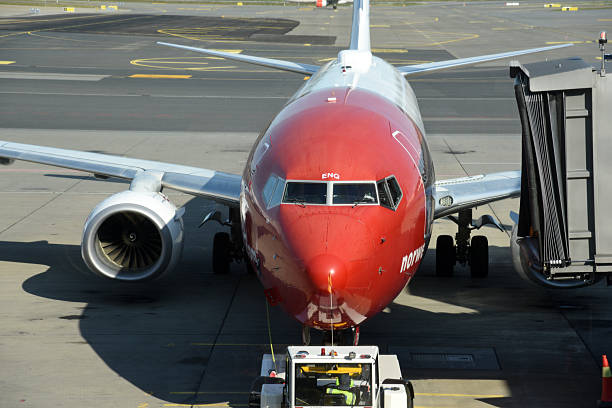 Oslo Airport Gardermoen is an international airport serving Oslo, the capital and most populous city of Norway. The image shows a norwegian aircraft at the gate, captured during summer season.