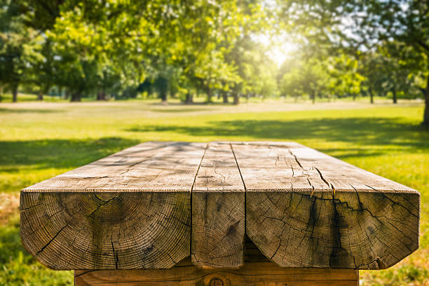 istock Wooden table with blurred sunny park background 2215777618