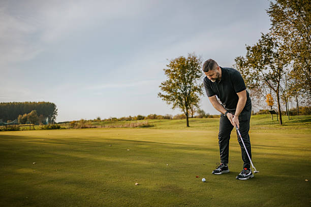 istock Man playing golf on a sunny day at a green golf course 2215782403
