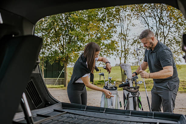 istock Couple preparing for a golf game by taking clubs from car 2215783494