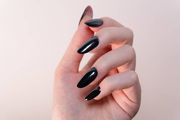 istock Black polish on oval nails captured on a white background — simplicity turned into a symbol of elegance. 2215783574