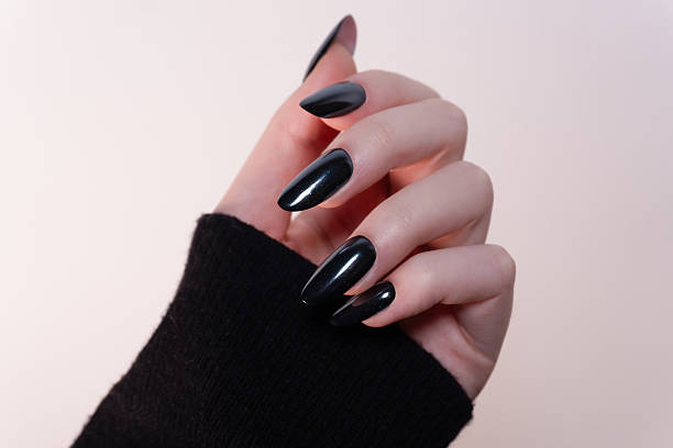 istock Hand with black manicure in natural light on a white background — a classic look with a touch of modern luxury. 2215783575