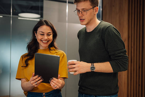 istock Young business colleagues looking at digital tablet and smiling during a coffee break 2215785852