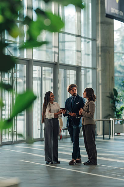 istock Businesspeople using digital tablet, discussing in modern office building lobby 2215787904