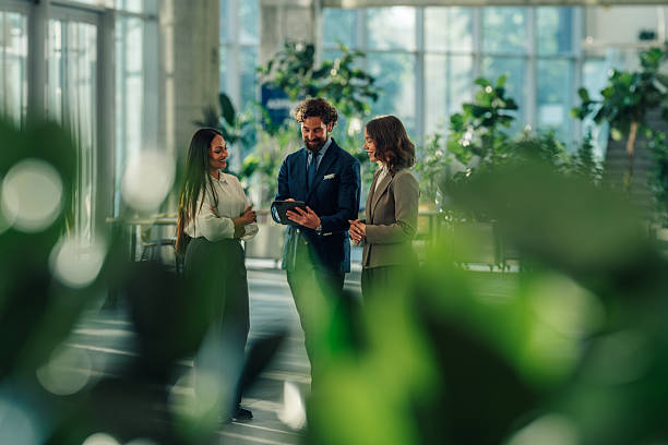 istock Businesspeople using digital tablet in modern office building lobby 2215787907