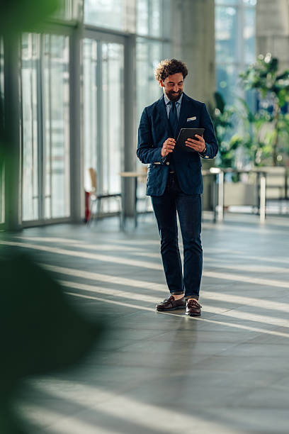 istock Businessman smiling and using digital tablet in modern office 2215787917