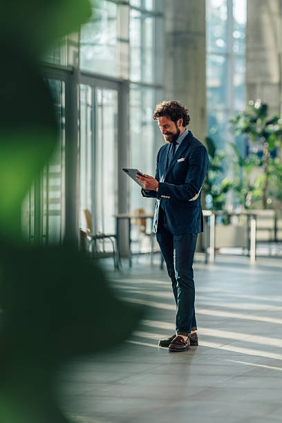 istock Businessman smiling and using digital tablet in modern office 2215787918