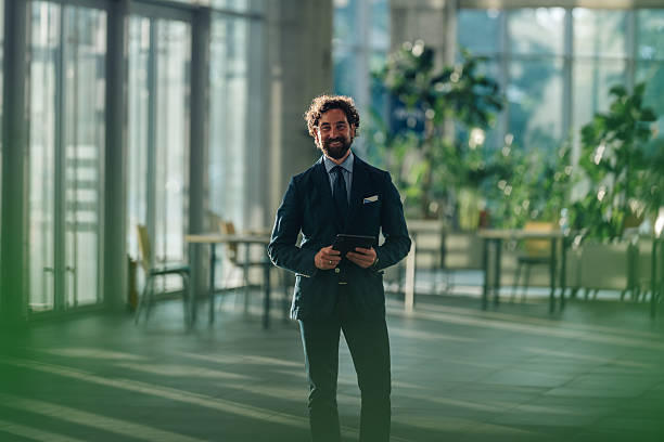 istock Smiling businessman holding digital tablet in modern office 2215787927