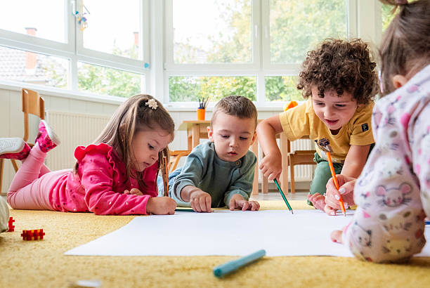 istock children draw on a large poster in kindergarten 2215788875