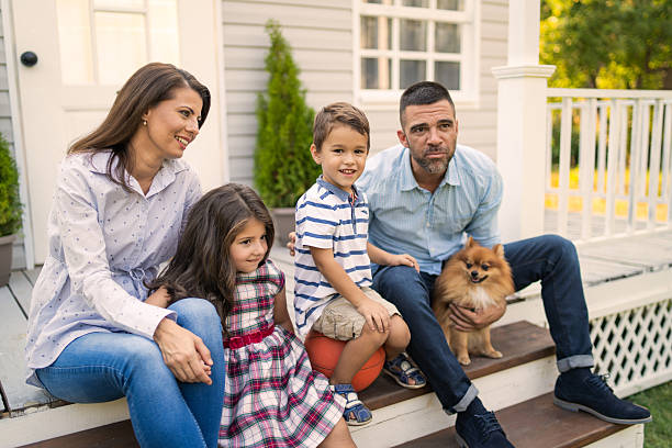 istock Smiling family sitting on front steps 2215795831
