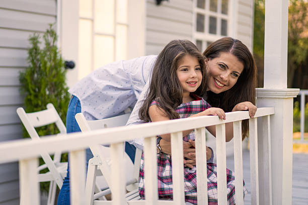 istock Mother and daughter leaning on front railings 2215795832