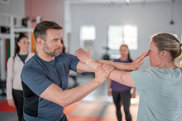 istock Women Training Self-Defense Techniques in a Martial Arts Classroom Setting 2215798507