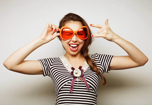 Party image. Playful young woman with big party glasses and crown. Ready for good time.