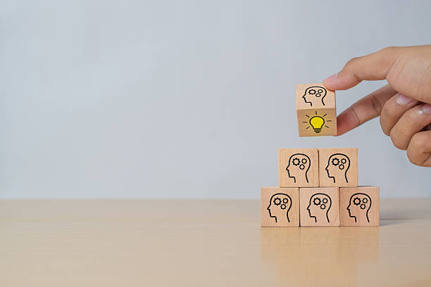 istock Concept creative idea and innovation. Hand flip over wooden cube block with head human symbol and light bulb icon 2215805944