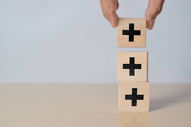 istock Hand stacking plus sign which print on wooden cube block for addition and positive mindset thinking concept. 2215805988