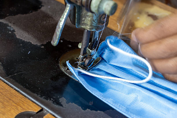 istock A making face masks from sterilization wrapping paper on a sewing machine. A homemade produce of masks to protect against dirt, smog and virus, close up. 2215809711