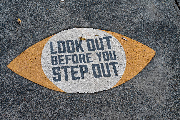 istock Warning sign on a pavement near a pedestrain crossing. 2215809910