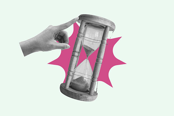 istock Hand pointing and pushing hourglass with sand falling, running out of time concept 2215818895
