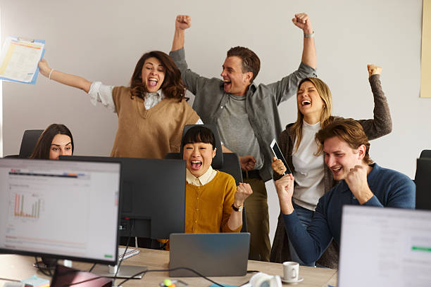 istock Team of cheerful computer programmers celebrating success in the office. 2215821680