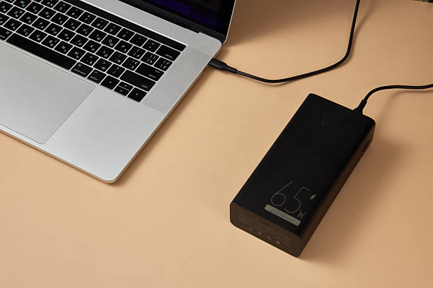 istock Charging laptop with power bank on beige background 2215823006