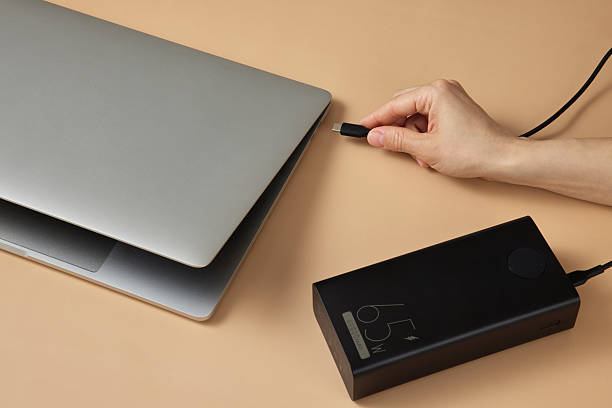 istock Charging laptop with power bank on beige background 2215823008