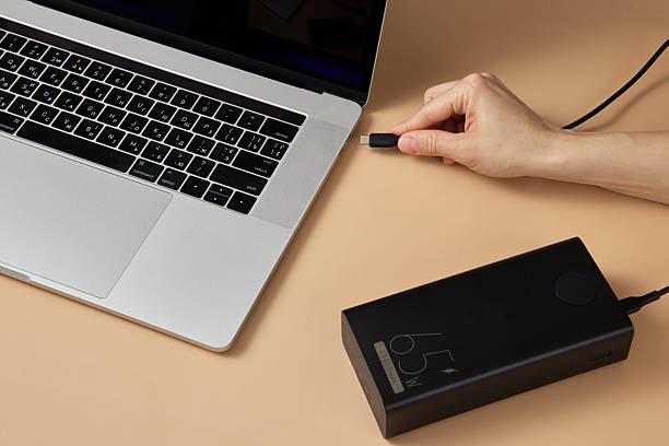 istock Charging laptop with power bank on beige background 2215823021