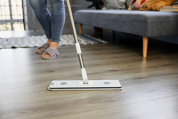 istock Woman mopping, wiping floor in modern home setting 2215823820