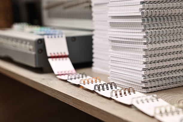 istock Stacks of notebooks and double loop wire binding spines on wooden table indoors, closeup 2215824088
