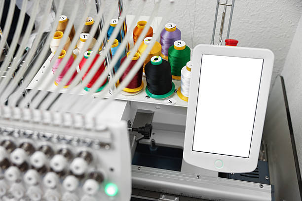 Modern embroidery machine with spools of thread indoors, closeup